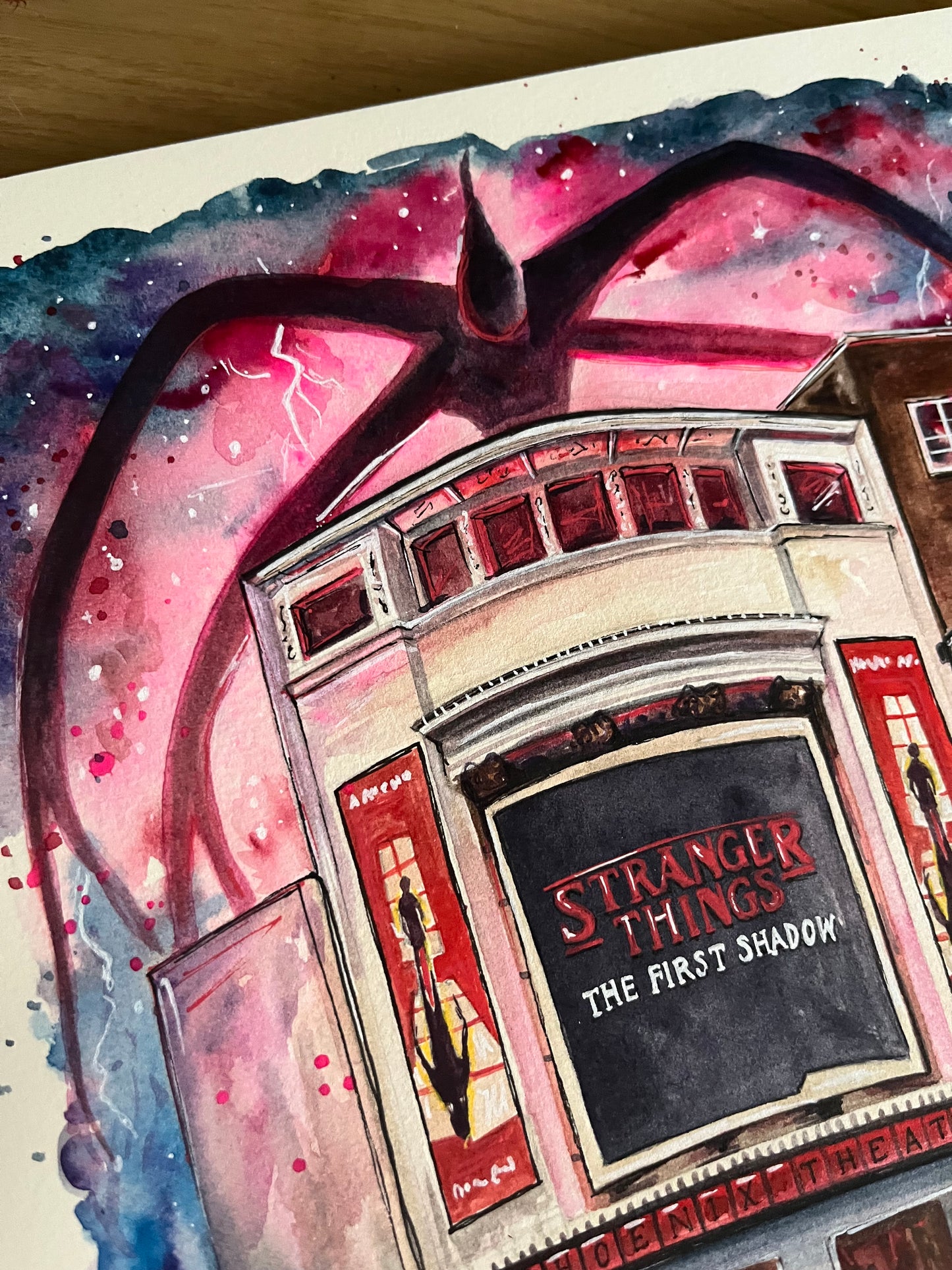 An original watercolour painting of the Phoenix Theatre in London’s West End by Eve Leoni Art, featuring Stranger Things: The Furst Shadow. 