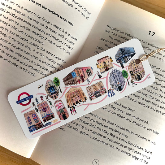 A musical theatre bookmark featuring West End theatres painted in watercolours by Eve Leoni Art. Complete with a golden tassle and laid on the popular book, ‘The Curious Incident of the Dog in the Nighttime.’